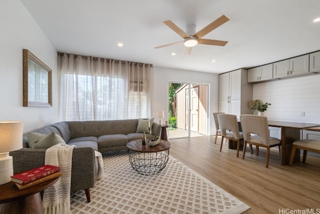 living room with ceiling fan and light hardwood / wood-style flooring