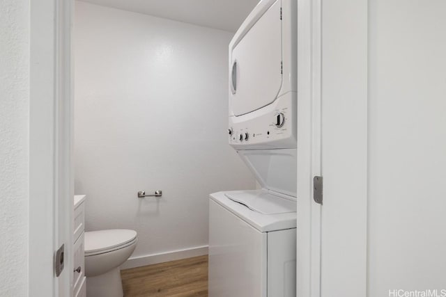 laundry area with wood-type flooring and stacked washer and clothes dryer