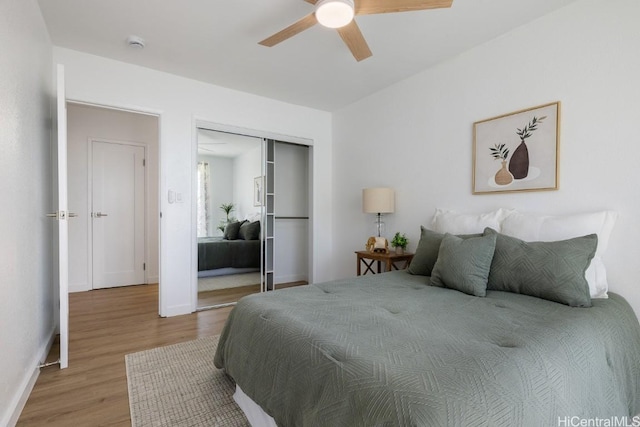 bedroom with light hardwood / wood-style flooring, a closet, and ceiling fan