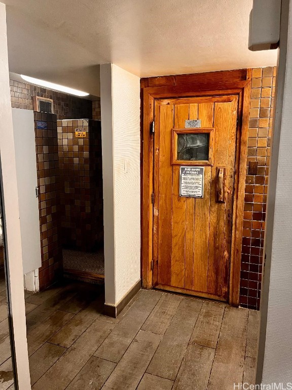 corridor with hardwood / wood-style flooring and a textured ceiling