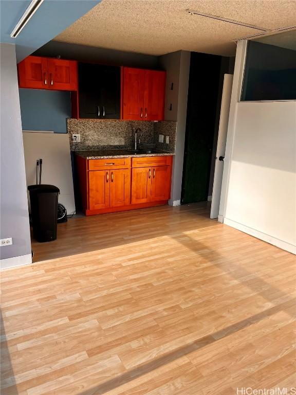 kitchen with sink, light hardwood / wood-style floors, and decorative backsplash