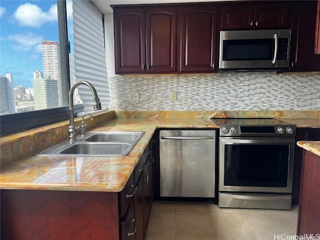 kitchen featuring sink, light tile patterned floors, stainless steel appliances, and tasteful backsplash