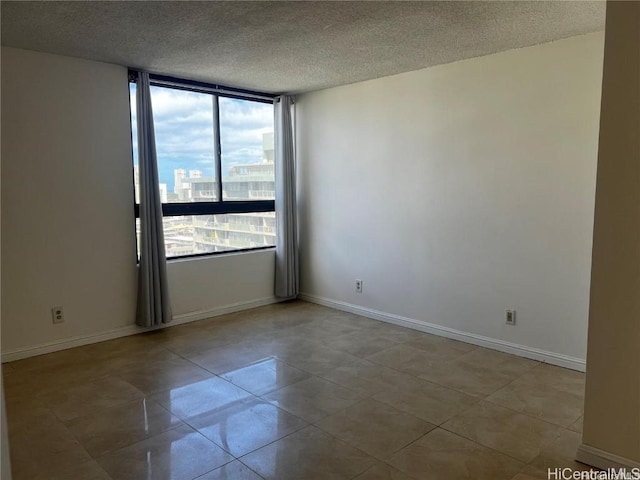 empty room with light tile patterned floors and a textured ceiling