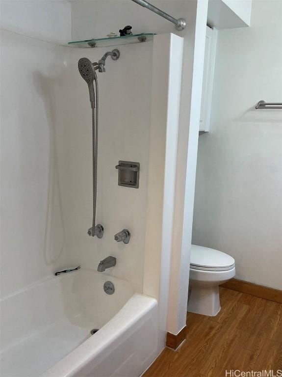 bathroom with hardwood / wood-style flooring, toilet, and bathtub / shower combination