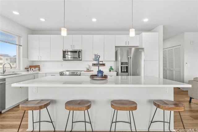 kitchen with hanging light fixtures, appliances with stainless steel finishes, and a center island