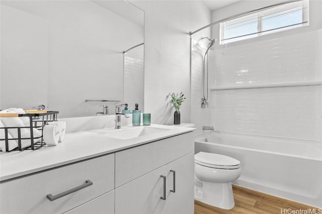 full bathroom featuring hardwood / wood-style flooring, vanity, shower / bathtub combination, and toilet