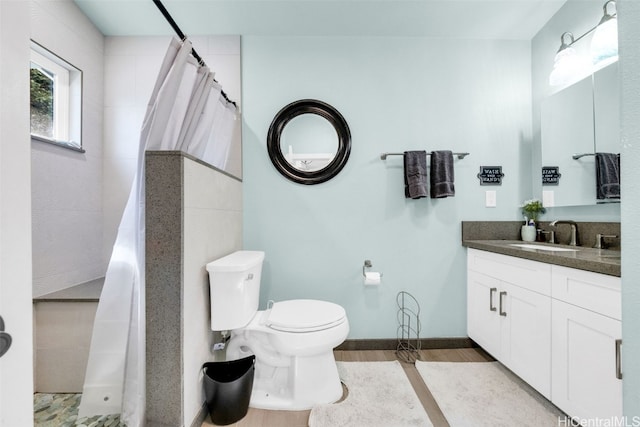 bathroom featuring a shower with curtain, toilet, vanity, and hardwood / wood-style flooring