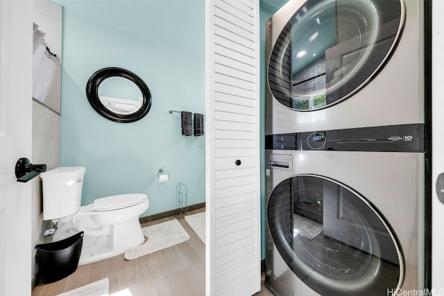 washroom featuring stacked washing maching and dryer and tile patterned floors