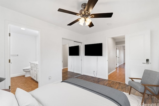 bedroom with ensuite bathroom, ceiling fan, light hardwood / wood-style flooring, and a closet