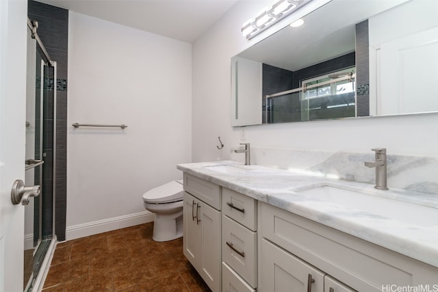 bathroom with a shower with door, vanity, and toilet