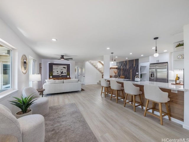 living room with ceiling fan and light wood-type flooring