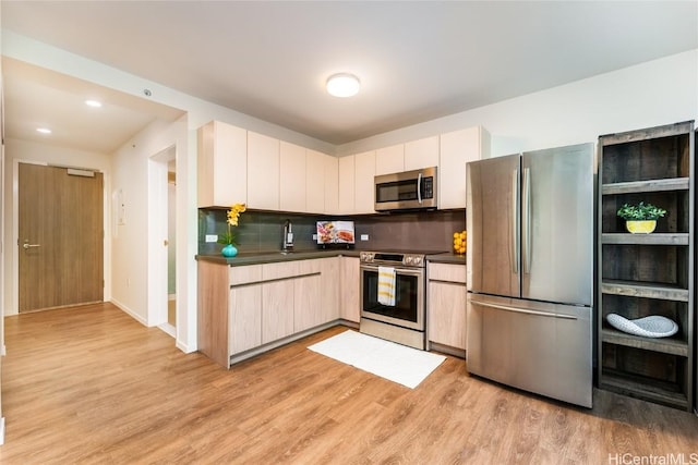 kitchen featuring decorative backsplash, light wood-type flooring, and stainless steel appliances