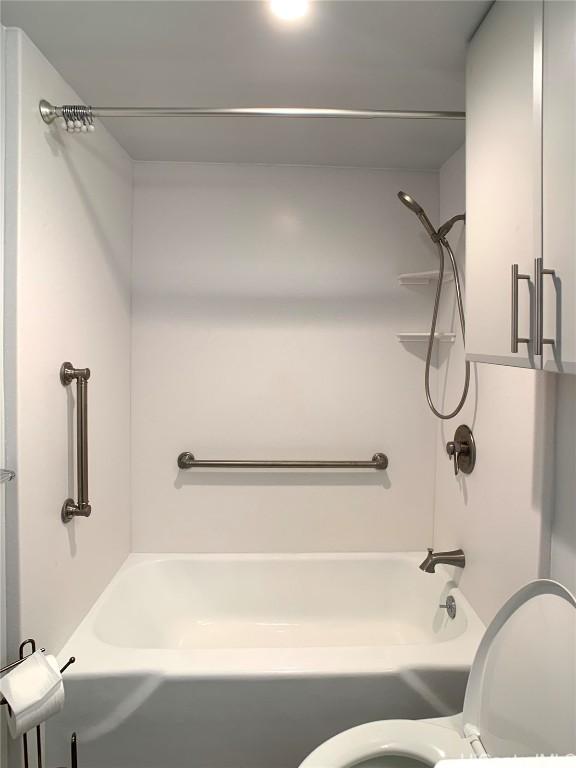 bathroom featuring shower / tub combination and toilet