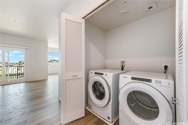 laundry area with light hardwood / wood-style flooring and washer and clothes dryer