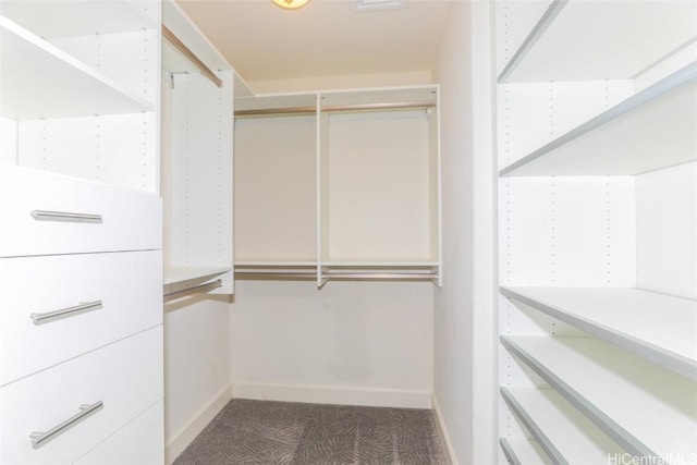 spacious closet featuring dark carpet