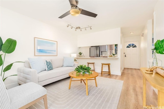 living room with ceiling fan and light hardwood / wood-style floors