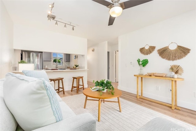 living room with ceiling fan and light hardwood / wood-style flooring