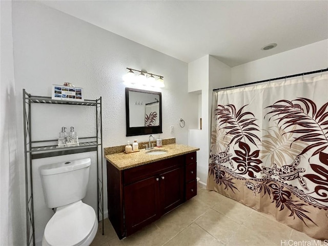 bathroom featuring walk in shower, tile patterned flooring, vanity, and toilet