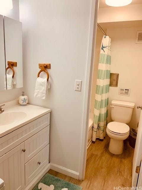 full bathroom featuring shower / bath combo with shower curtain, toilet, vanity, and hardwood / wood-style flooring