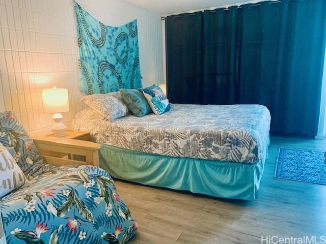 bedroom featuring wood-type flooring and tile walls