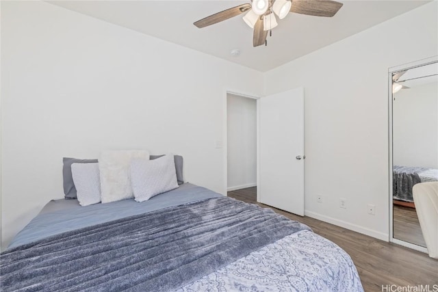 bedroom with ceiling fan, a closet, and dark wood-type flooring