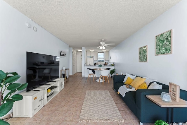 tiled living room with ceiling fan and a textured ceiling