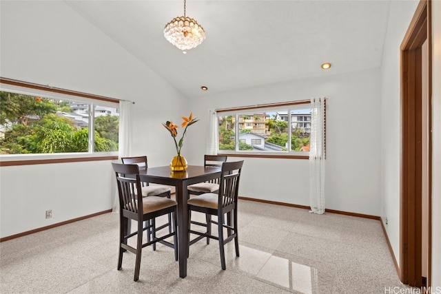 dining space featuring an inviting chandelier and lofted ceiling