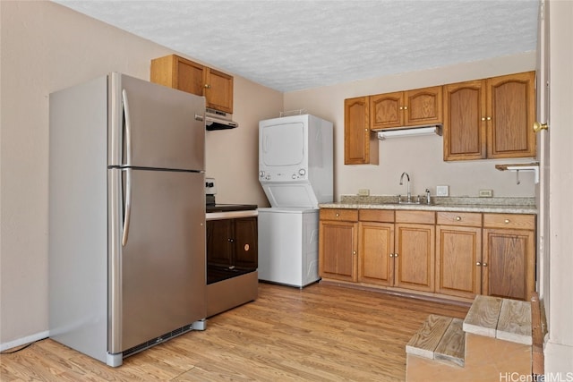 kitchen with sink, light hardwood / wood-style flooring, extractor fan, and appliances with stainless steel finishes