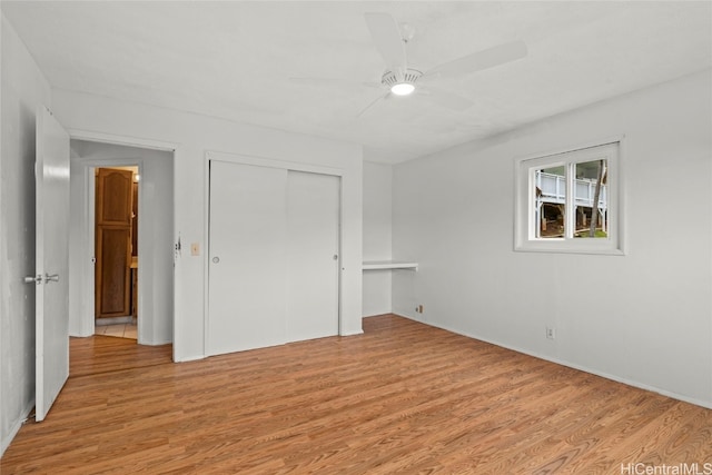 unfurnished bedroom featuring ceiling fan, a closet, and light hardwood / wood-style flooring