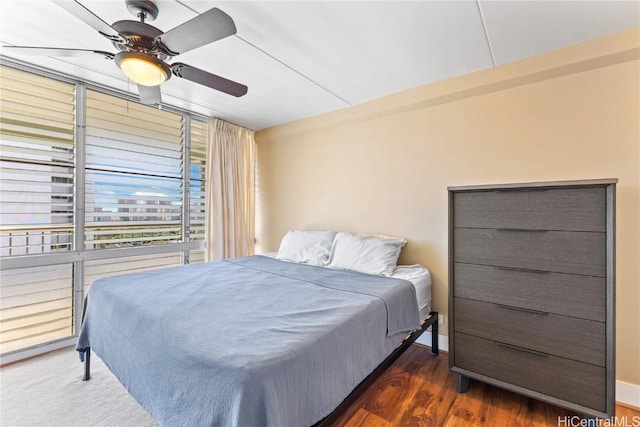 bedroom with dark hardwood / wood-style floors and ceiling fan