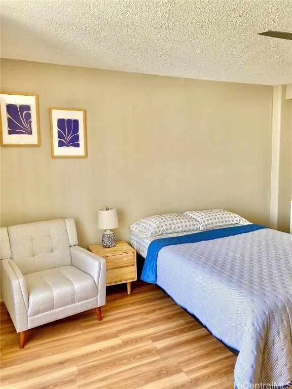 bedroom featuring hardwood / wood-style floors and a textured ceiling