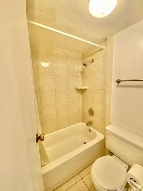 bathroom with tile patterned floors, tiled shower / bath, and toilet