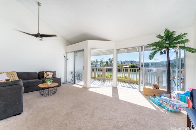 living room featuring carpet flooring, a water view, high vaulted ceiling, and ceiling fan