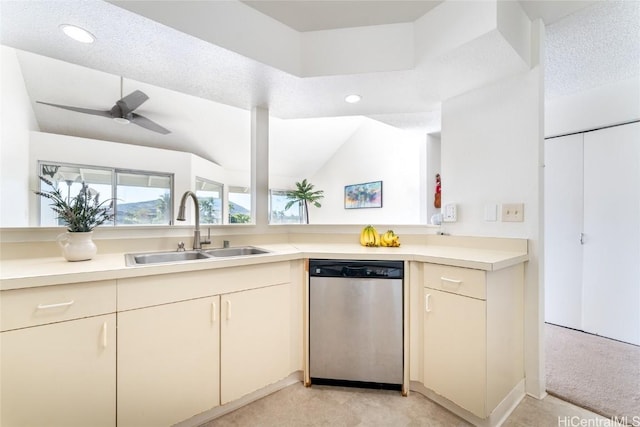 kitchen featuring ceiling fan, sink, stainless steel dishwasher, lofted ceiling, and a textured ceiling