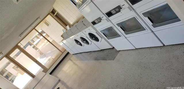 washroom with washing machine and dryer, a towering ceiling, stacked washing maching and dryer, and a textured ceiling