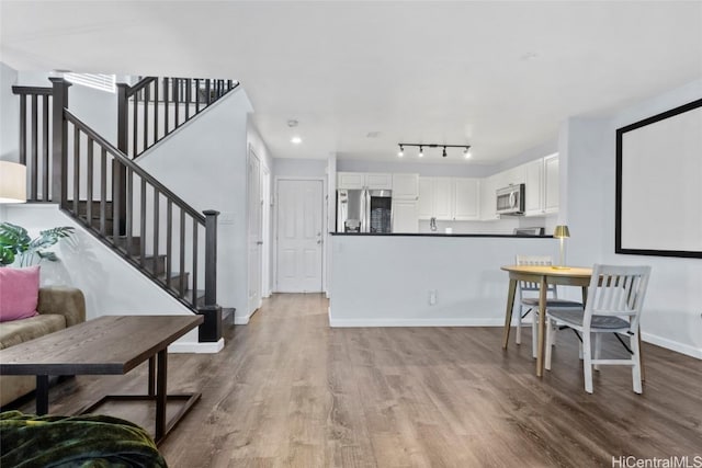 interior space featuring rail lighting and light hardwood / wood-style floors