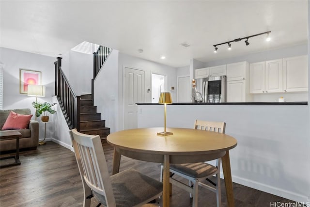 dining space featuring dark hardwood / wood-style floors and track lighting