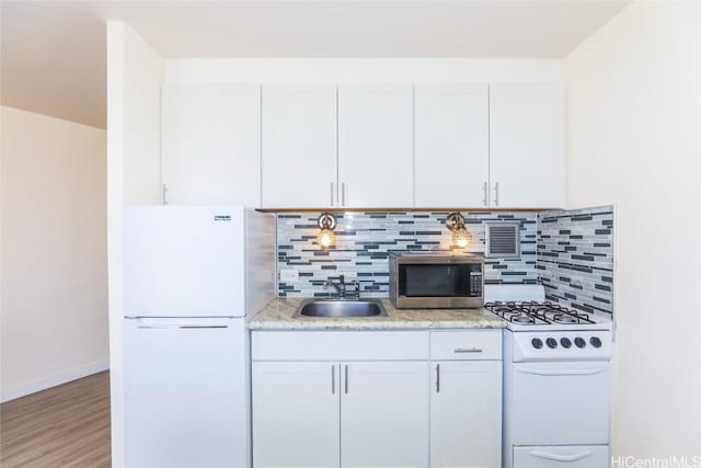 kitchen with hardwood / wood-style flooring, white cabinetry, white appliances, and sink