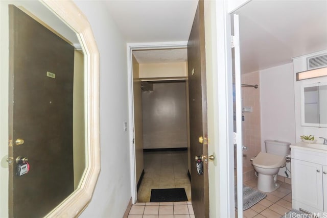 bathroom featuring tile patterned flooring, vanity, and toilet