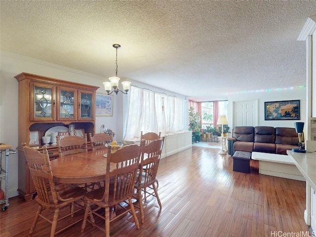 dining space with hardwood / wood-style floors, a textured ceiling, and an inviting chandelier