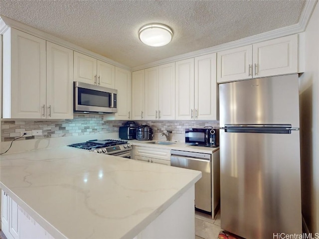 kitchen featuring white cabinetry, sink, light stone countertops, and stainless steel appliances