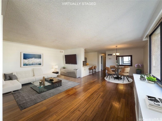 living room with hardwood / wood-style floors, a textured ceiling, and a chandelier