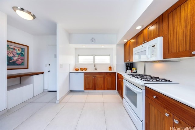 kitchen with sink, white appliances, and light tile patterned floors