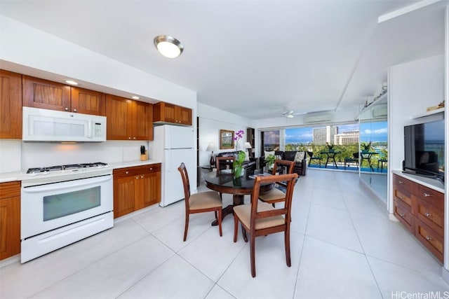 kitchen with light tile patterned floors, white appliances, a wall mounted AC, and ceiling fan