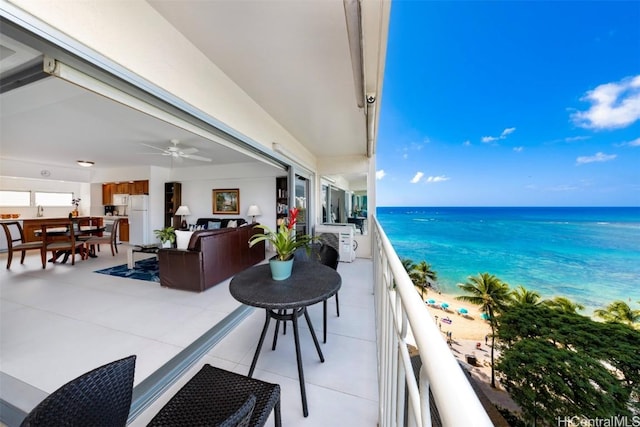 balcony featuring a water view, an outdoor hangout area, ceiling fan, and a view of the beach