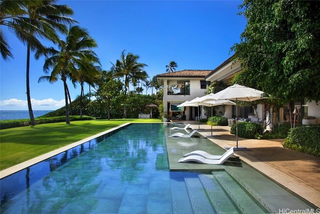 view of swimming pool featuring a lawn and a hot tub