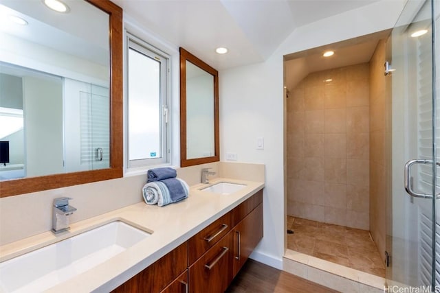 bathroom featuring a shower with door, vanity, lofted ceiling, and hardwood / wood-style flooring