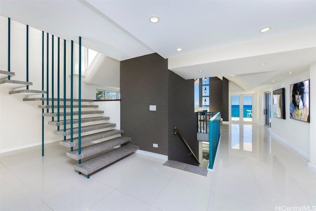 stairway with tile patterned floors, a water view, and french doors