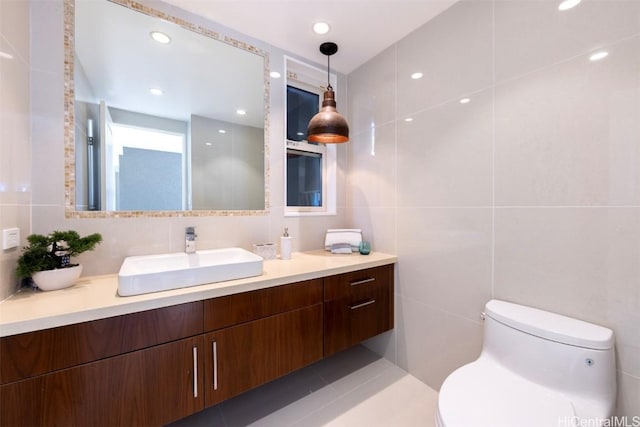 bathroom with tile patterned flooring, vanity, toilet, and tile walls