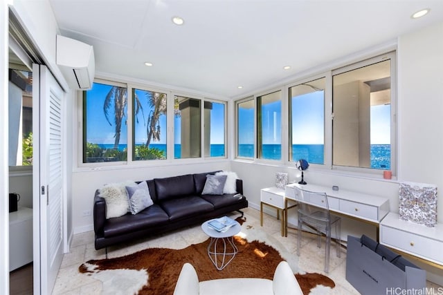 living room featuring a wall mounted air conditioner, a water view, and a wealth of natural light